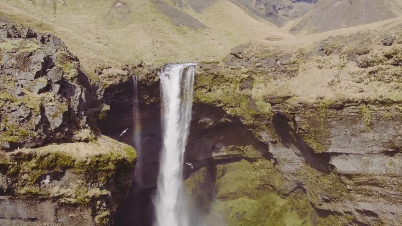 Hidden Waterfall, Kvernufoss, sunny day. Aerial pan right