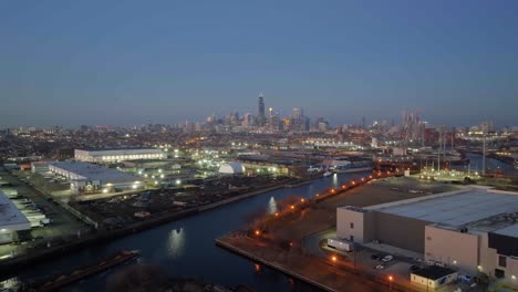 Aerial-view-passing-a-cargo-ship-moving-towards-the-Chicago-skyline,-misty-evening-in-Illinois,-USA