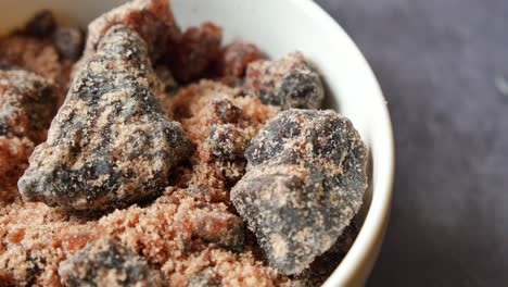 cristales de roca de sal negra del himalaya, kala namak en un recipiente en la mesa