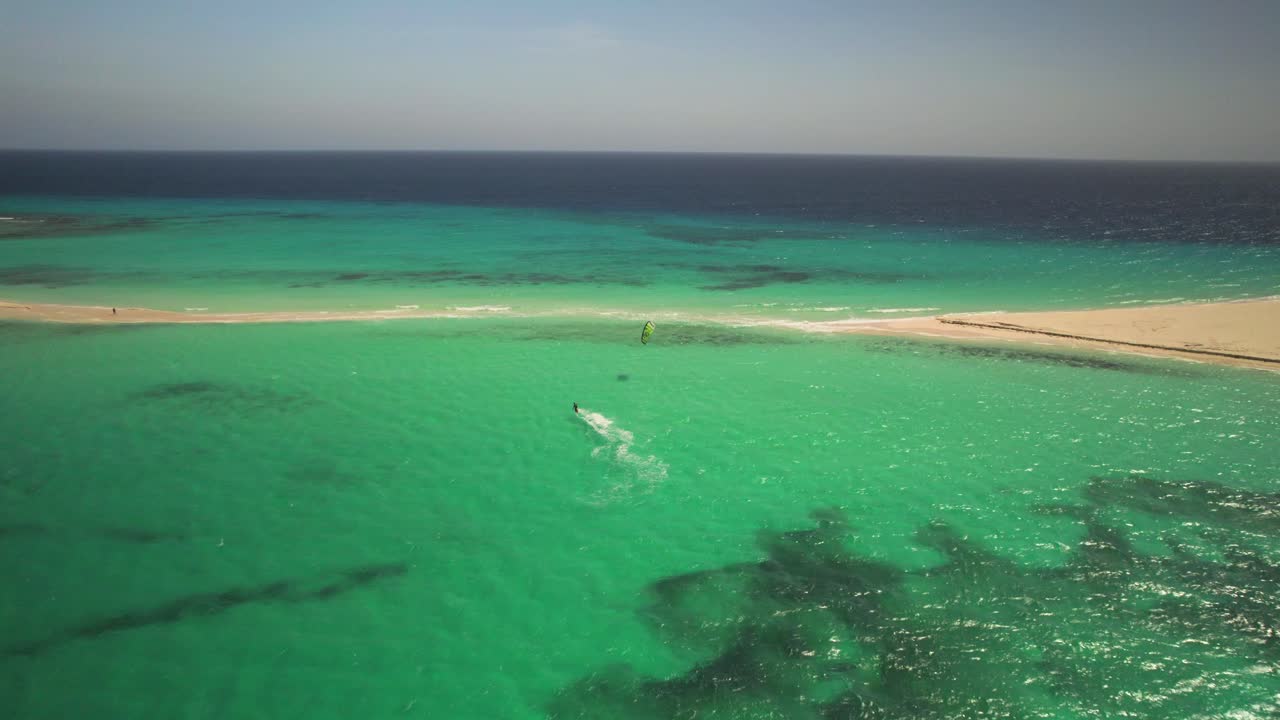 드론으로 찍은 샌디 케이 근처의 푸른 물 위를 날아다니는 카이트 서퍼