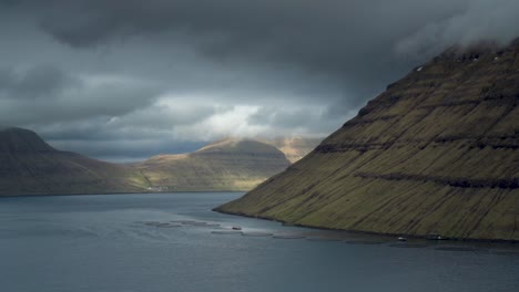 kunoy island under cloudy dark sky in faroe islands, denmark