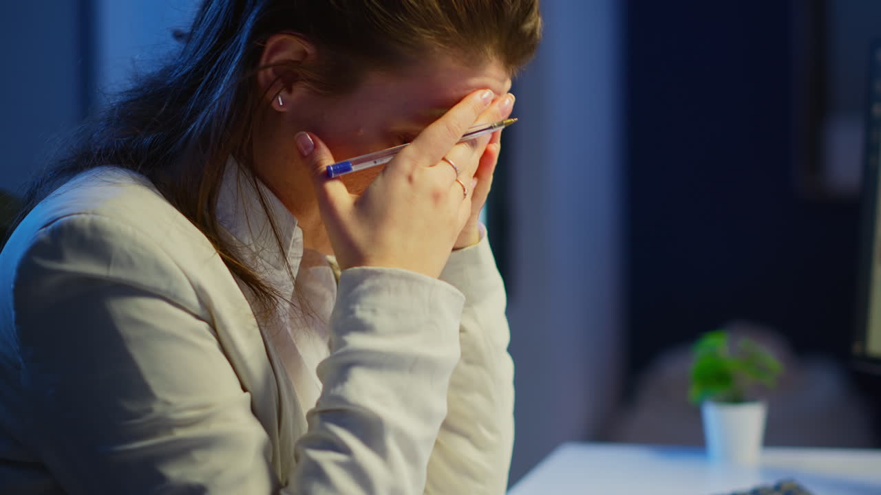 Primo piano di donna stressata con mal di testa che lavora fino a tardi