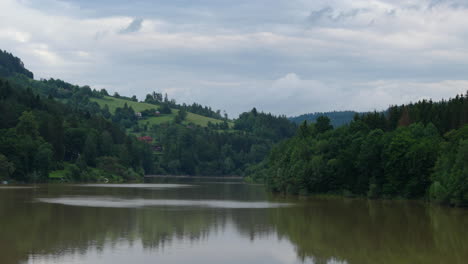 Paisaje-Ampliado-Con-Casas-Al-Pie-De-Las-Colinas-Y-Un-Entorno-Lleno-De-Naturaleza-Con-Muchas-Nubes-En-El-Cielo-En-La-Zona-Del-Embalse-De-Bystricka