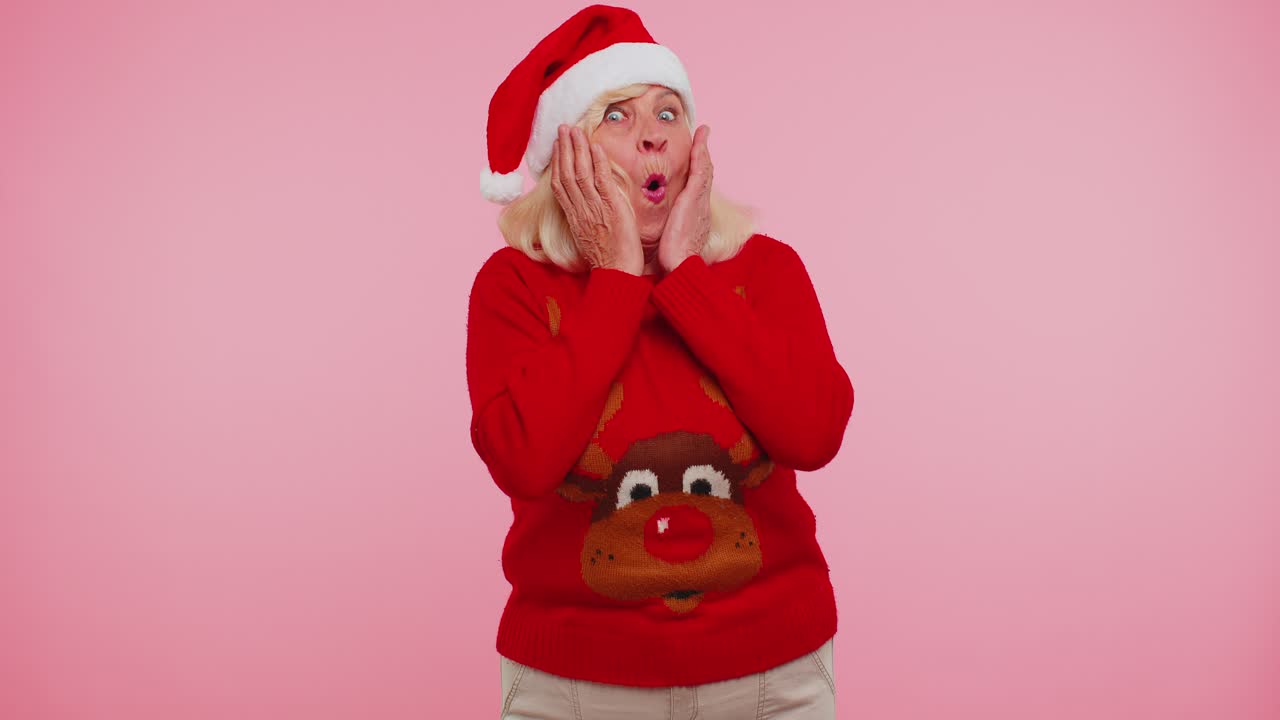 새해에 할머니는 사 스웨터를 입고 놀라서 손을 들고 갑작스러운 승리에 충격을 받았습니다.