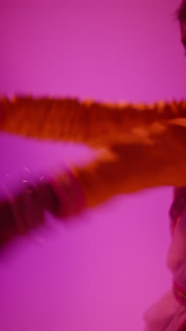 vertical video close up on hands of female kathak dancer performing dance wearing traditional indian dress against purple background 1