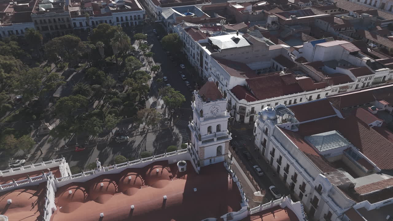 Drone shot of Sucre Bolivia on a bright day with blue sky with a view over the main square in the middle of the city with the church tower in the centerLOG