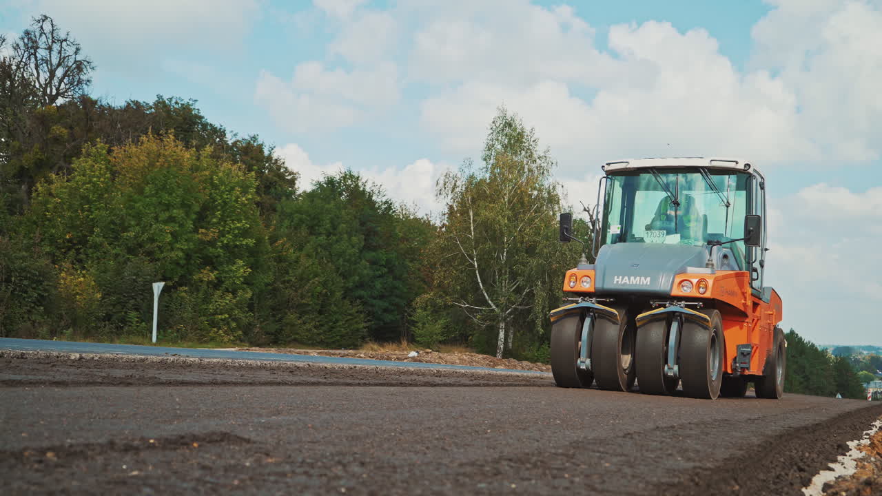Heavy asphalt roller that stack and press hot asphalt. Road repair machine. Repairing in modern city with vibration roller compactor