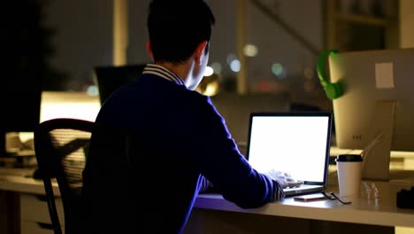 male executive using laptop at desk in office 4k