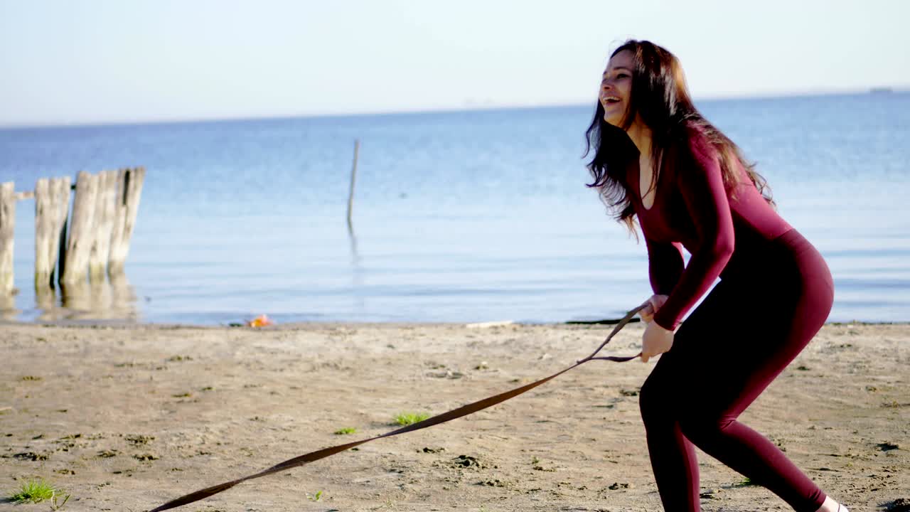 강변, 해변에서, 해가 뜨면, 은 옷을 입은 아름다운 여자가 질 품종의 개와 함께 고, 개를 줄에 어두고, 개와 함께 놀고, 재미있습니다.