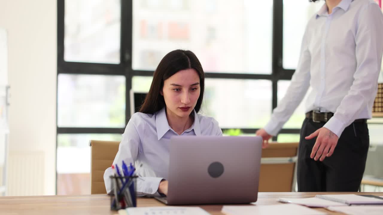 Colleagues collaborating and discussing work in an office setting