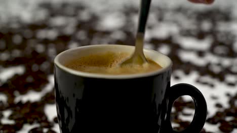 steady shot of someone stirring a fresh cup of coffee