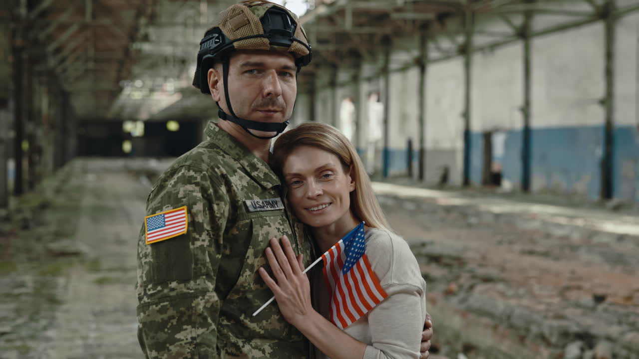 Soldier and Wife embrace in a desolate factory