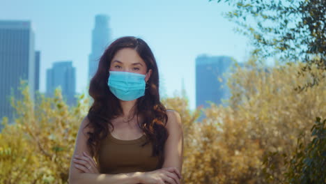 asian model in mask looking camera in park closeup. brunette care of health.