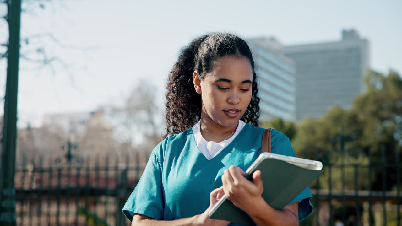 Nurse using tablet outdoors
