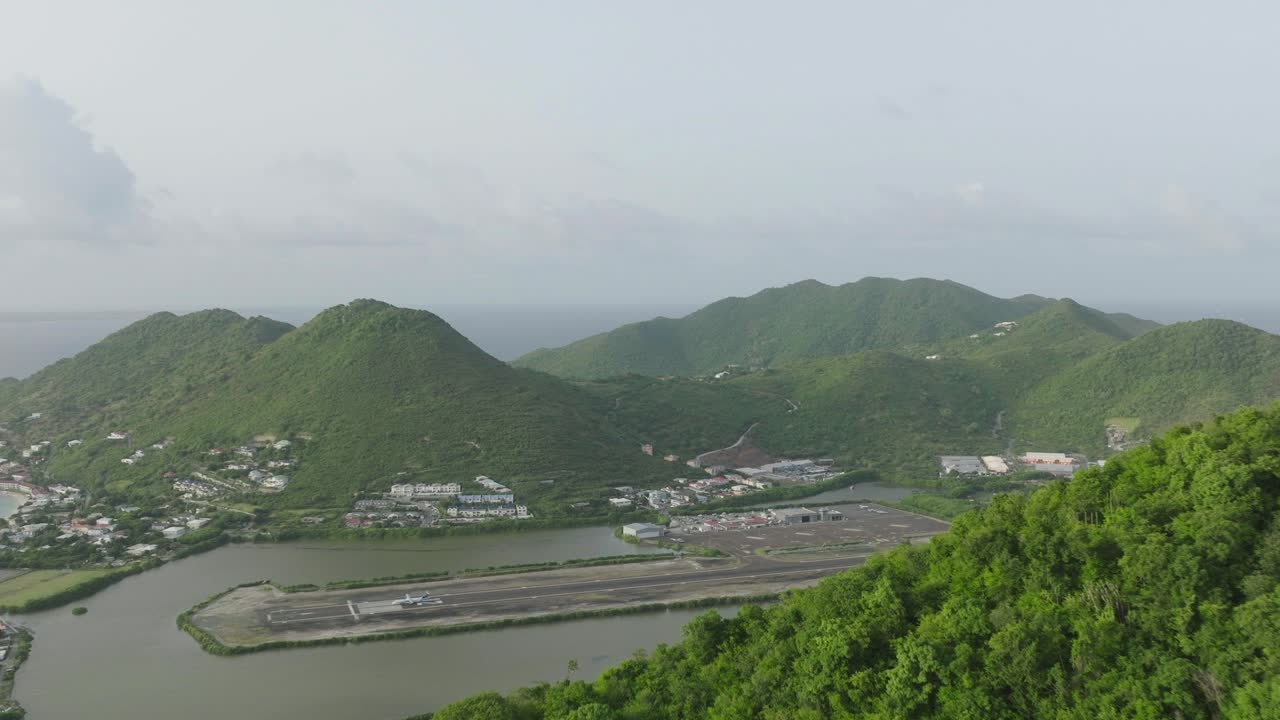 세인트 마틴에서 출발하는 비행기와 함께 그랜드 케이스 공항의 공중 이동 과 아름다운 카리브 해 풍경 배경