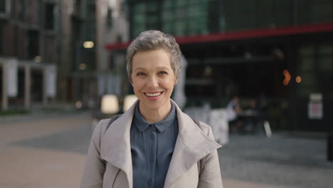 portrait of mature professional business woman smiling happy wearing stylish coat in city enjoying urban evening commuting