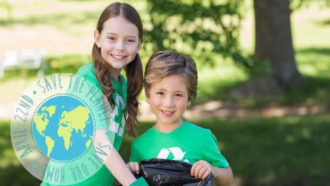 animation of ecology text and globe logo over smiling boy and girl doing clean up work in forest