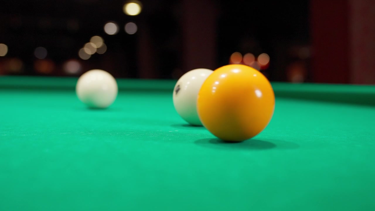 Billiard Balls Colliding on a Green Pool Table