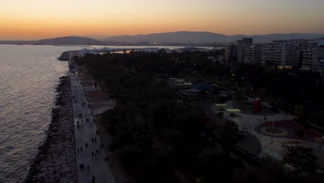 an impressive low altitude aerial drone shot of the entire floisvos area in athens during sunset