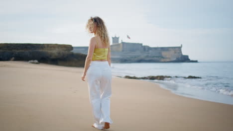 romantic girl walking seashore summer weekend. carefree woman strolling beach
