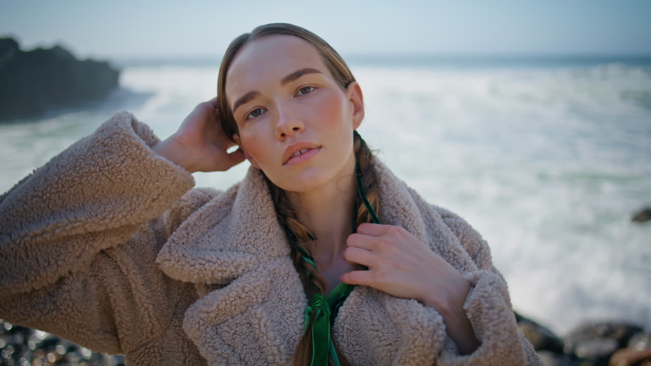 평화로운 모형 바다 연안에서 거품 물결 클로즈업. braids와 함께 패션 소녀