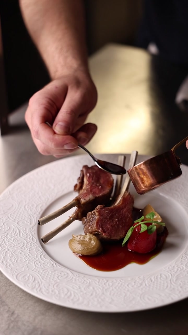 Chef Plating Gourmet Lamb Chops in Professional Kitchen