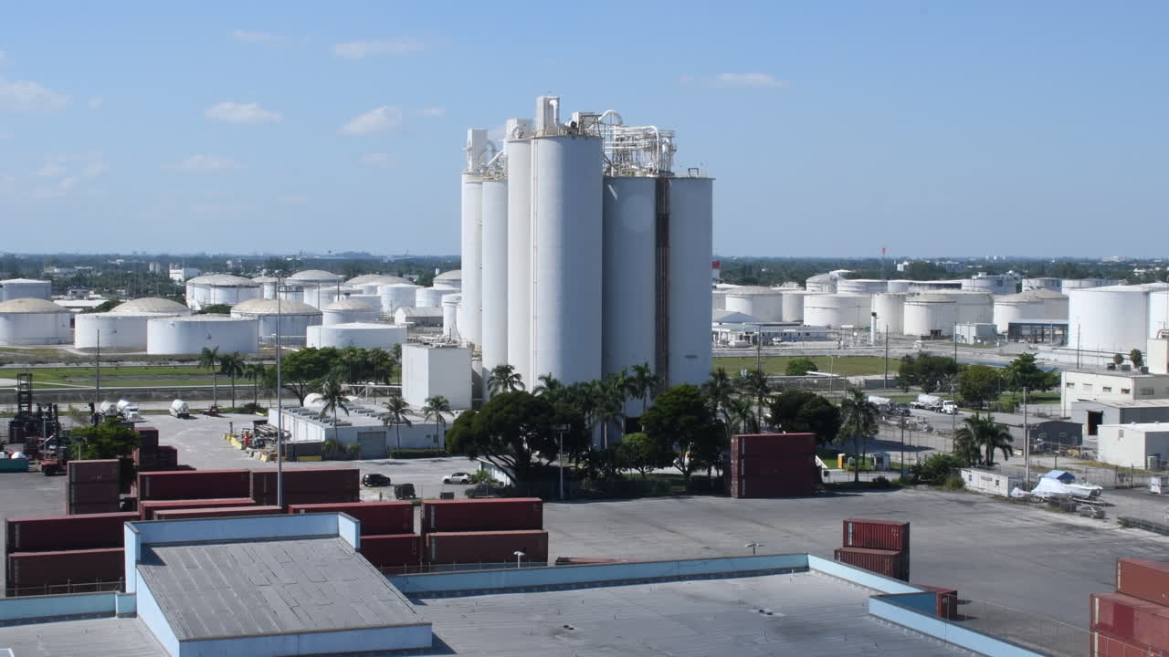 la colosal planta de energía limpia de gas natural emite olas de humo blanco, enmarcadas por la bandera de los estados unidos ondeando en primer plano, simbolizando la mezcla armoniosa de responsabilidad ambiental y orgullo nacional.