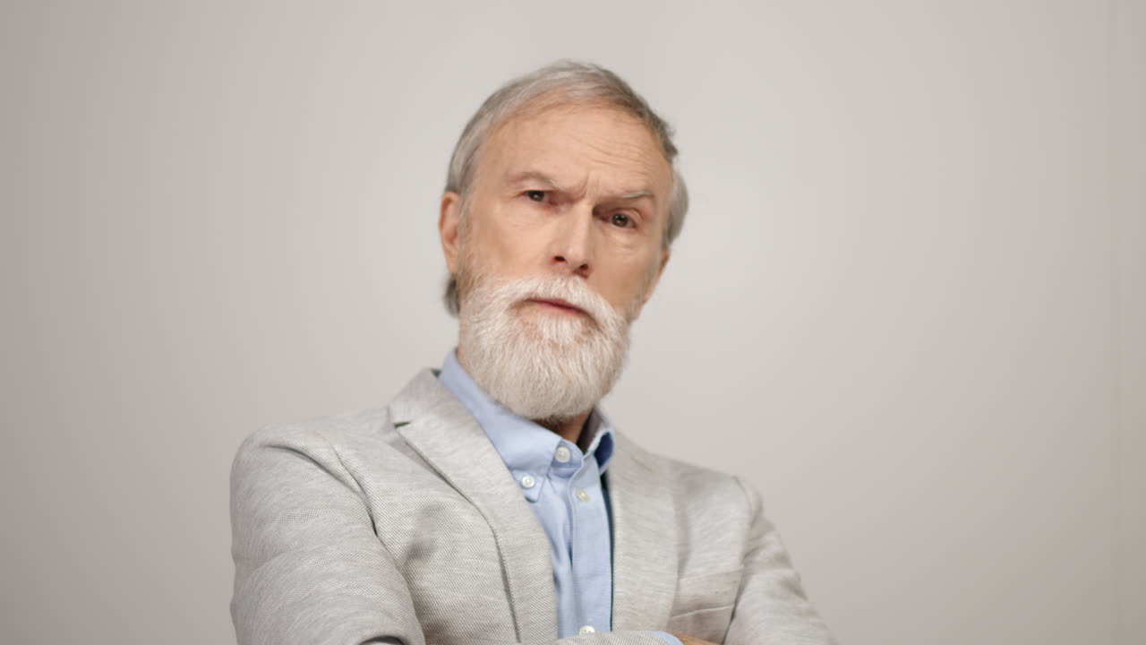 스튜디오에서 진지하게 보이는 남자 카메라, 자신감 넘치는 신사, 실내에서 팔을 는 남자