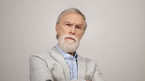 Serious-man-looking-camera-in-studio.-Confident-gentleman-crossing-arms-indoors.