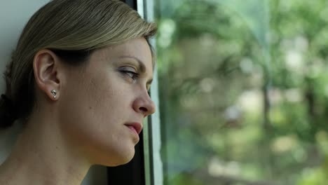 pensive woman looking out window