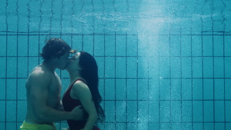 romantic couple kissing underwater in swimming pool young people in love enjoying intimate kiss lovers submerged in water floating with bubbles in passionate intimacy