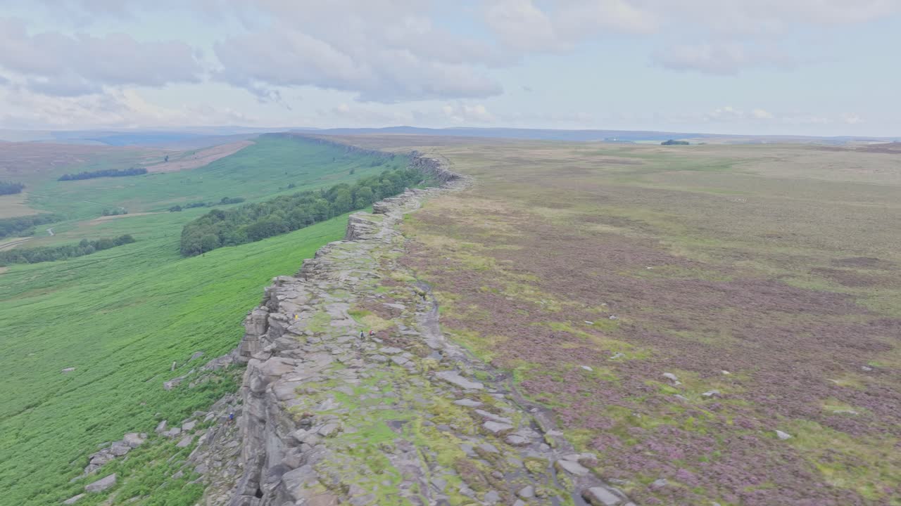 el avión no tripulado vuela de izquierda a derecha sobre la escarpa rocosa del borde del estadio en un día nublado