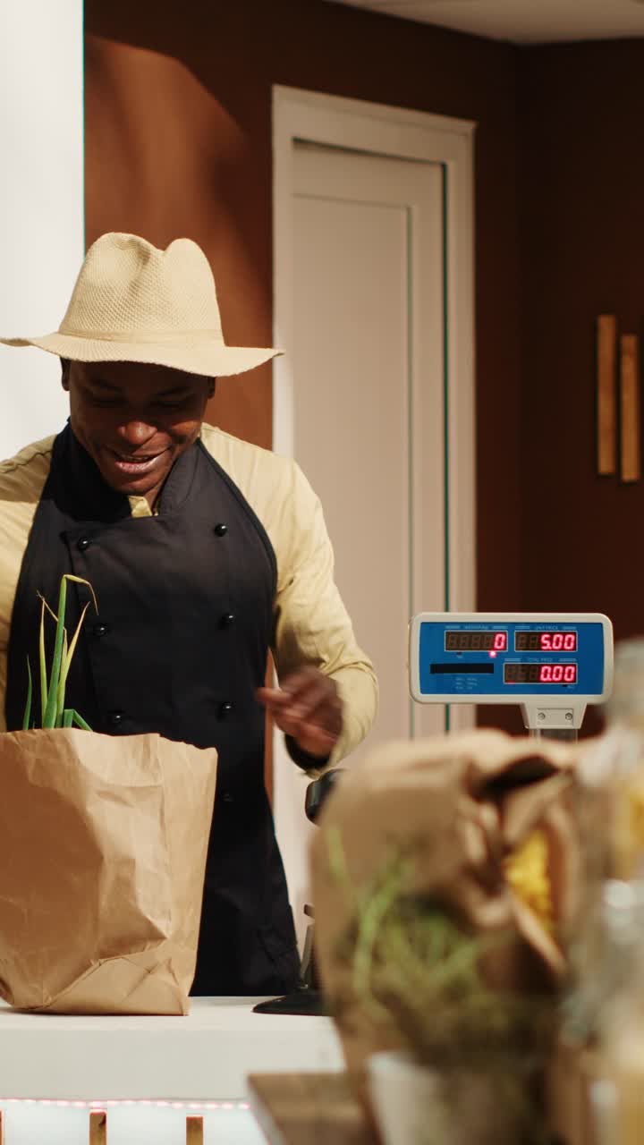Vertical Video African american vendor weighting produce for regular client at supermarket