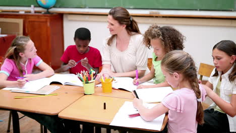 Teacher-sitting-at-a-table-with-pupils