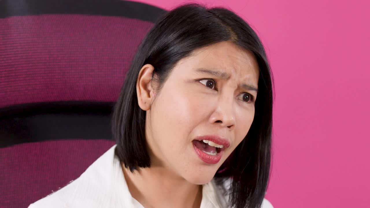 아시아 여성이 사무실 의자에 앉아 어깨를 으쓱하며 혼란스러움과 좌절감을 표현하고 있어요