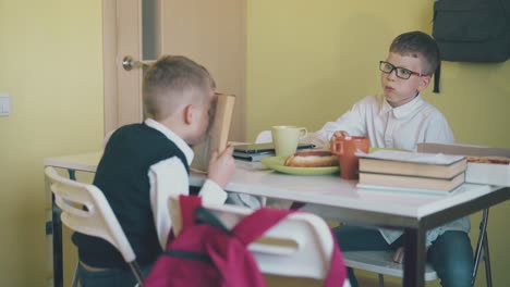 schoolboys-have-lunch-doing-homework-at-table-slow-motion