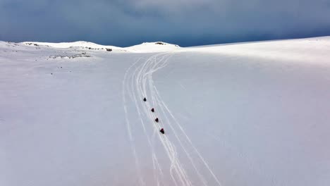 Aerial-panoramic-view-of-people-riding-snowmobiles-on-the-icy-ground-of-Myrdalsjokull-glacier-in-Iceland