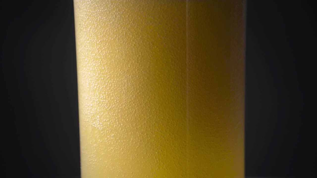 흐리고 흐릿한 필스너 에일 맥주가 유리잔에 쏟아지고 있다