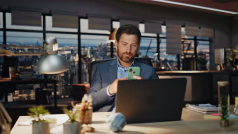 trabajador feliz leyendo el mensaje del teléfono inteligente en primer plano por la noche. gerente exitoso