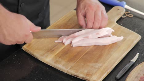 close-up of cutting pork fat into cubes for cooking