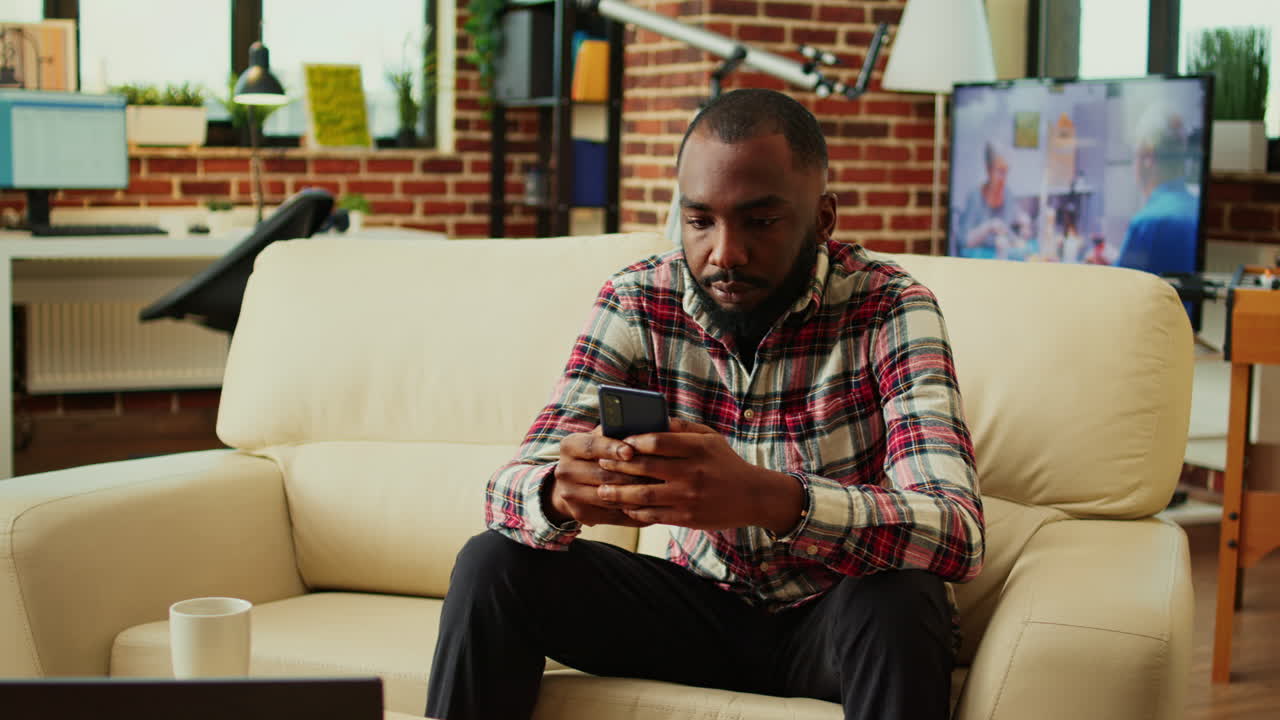 Man using cell phone on sofa indoors