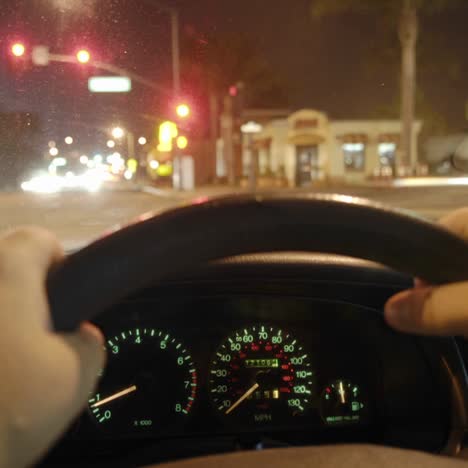 una persona conduce un automóvil por las calles luminosas de la ciudad