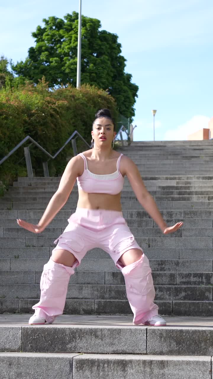 Woman in Pink Outfit Dancing on Stairs