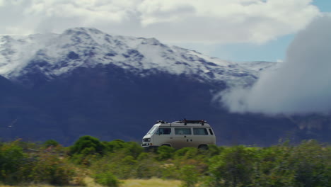 a van drives past the tall mountains