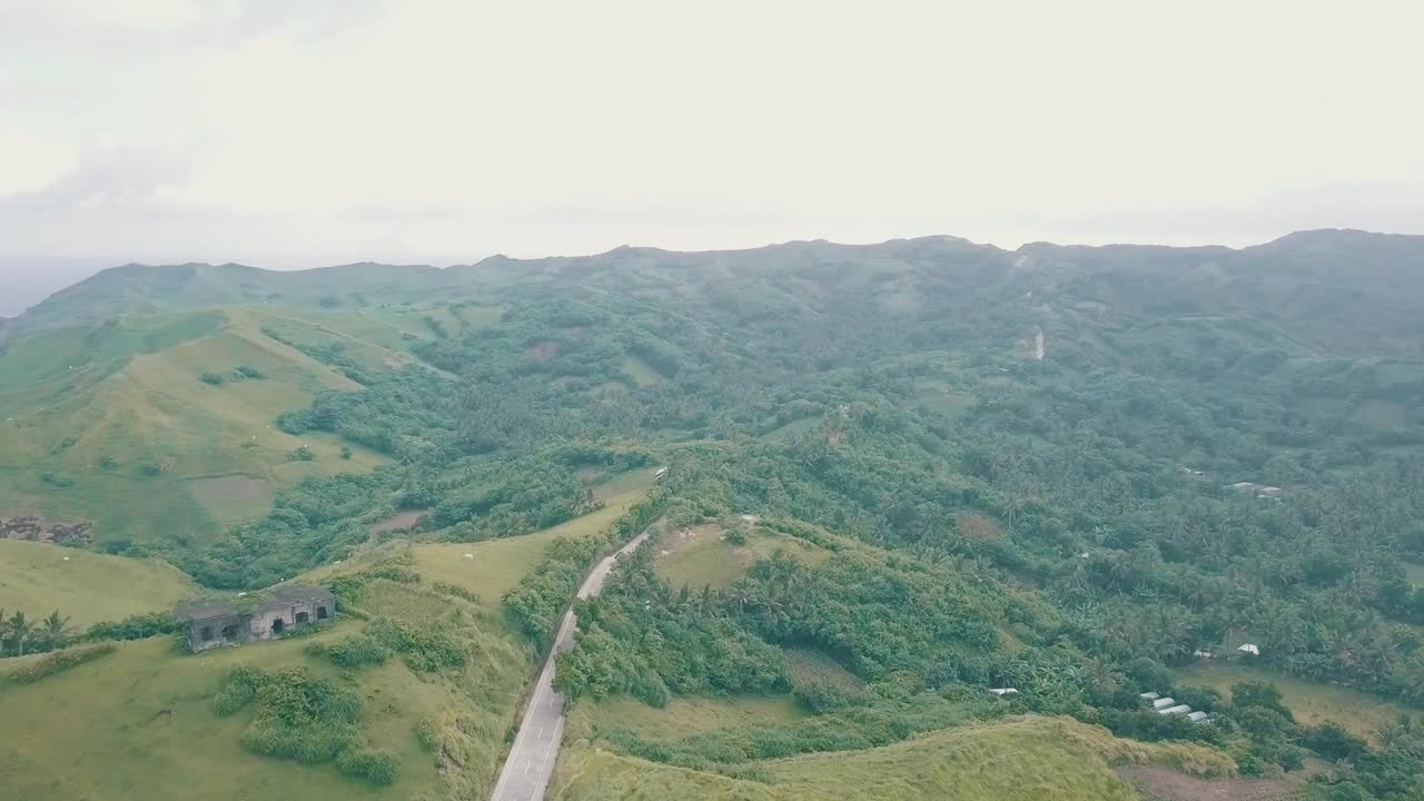 vista aérea cinematográfica de drones de un paisaje pintoresco del océano que se encuentra con montañas en batanes, filipinas
