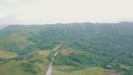 cinematic aerial drone view of a picturesque landscape of ocean meeting mountains in batanes, philippines