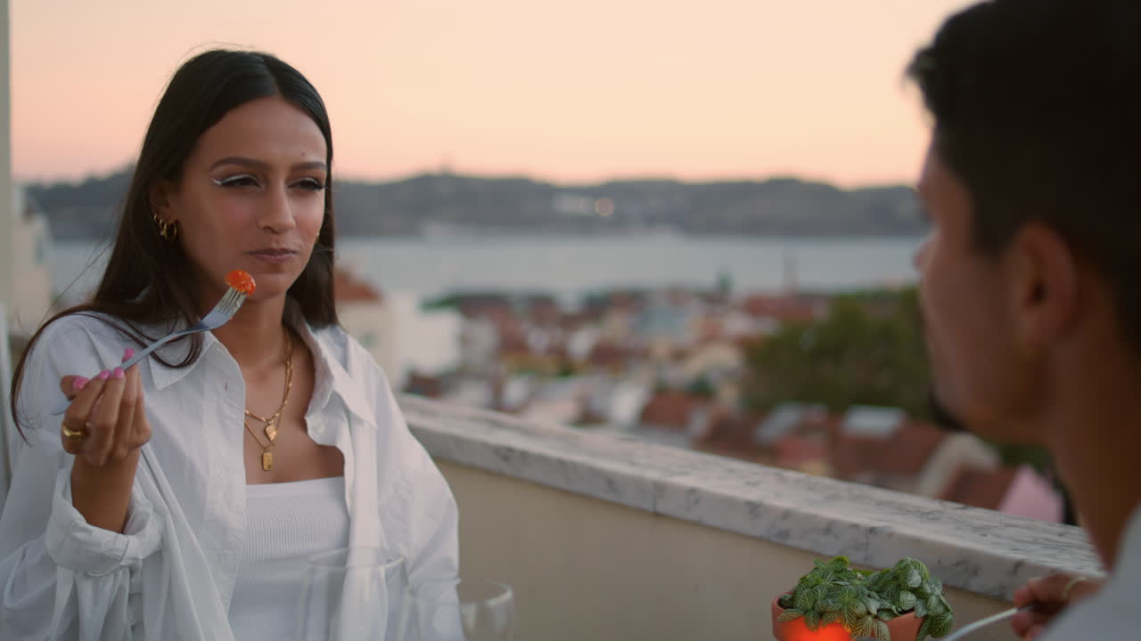 알 수 없는 남자가 발코니에서 아내를 대하고 있다. 연인들의 만적인 저녁