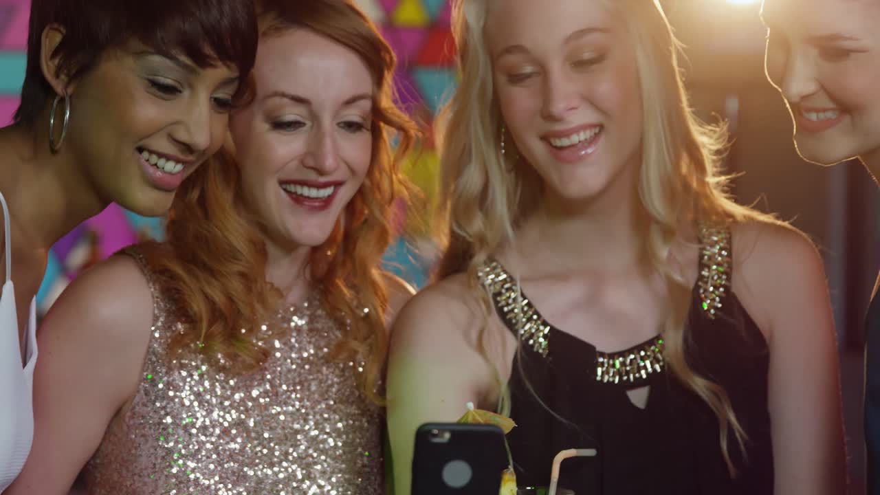 grupo de amigos felices mirando el teléfono móvil