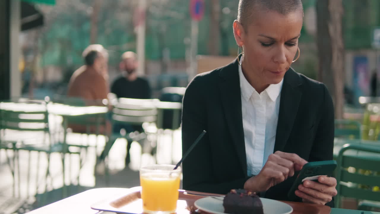Thoughtful Woman Using Smartphone at an Outdoor Cafe
