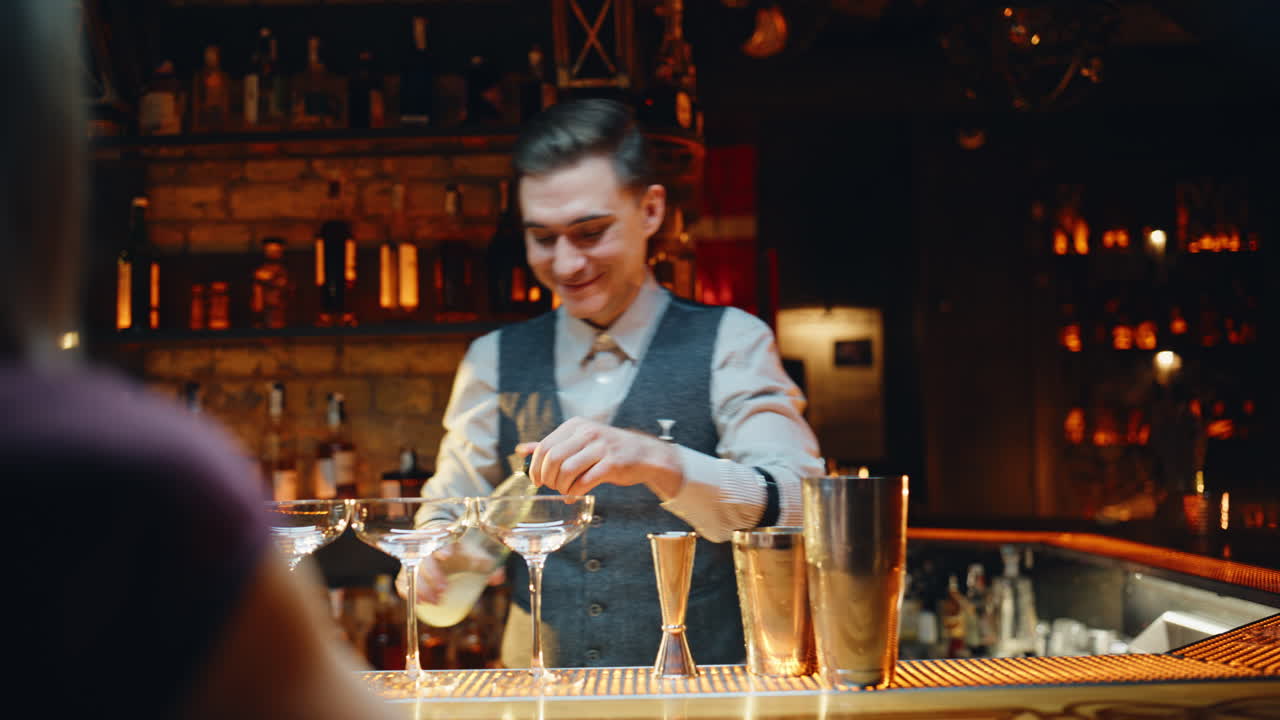 Positiver Barkeeper misst lebendige Lounge-Nahaufnahme mit Flüssigkeit. Mann schenkt Spirituosen ein